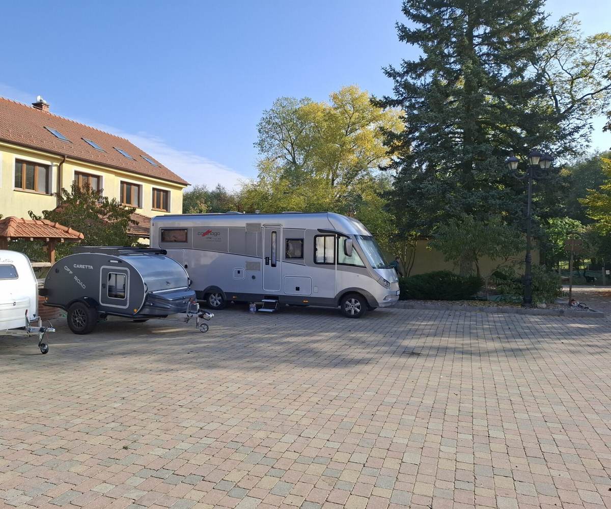 A motorhome and two small caravans on the paved courtyard