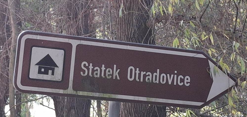 Brown tourist sign pointing to Statek Otradovice